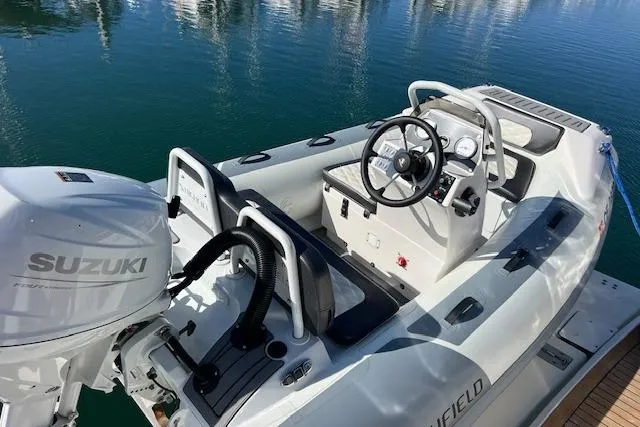 Slide: The Image of 1997 Sea Ray 450 Sundancer boat with Suzuki outboard motor, docked on calm water. - 13