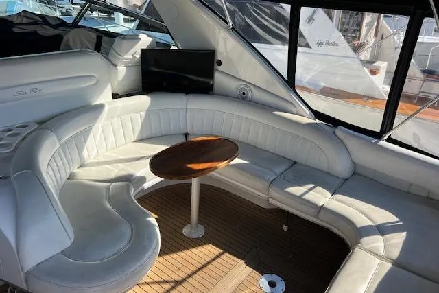 Slide: The Image of 1997 Sea Ray 450 Sundancer interior with white leather seating and wooden table. - 16