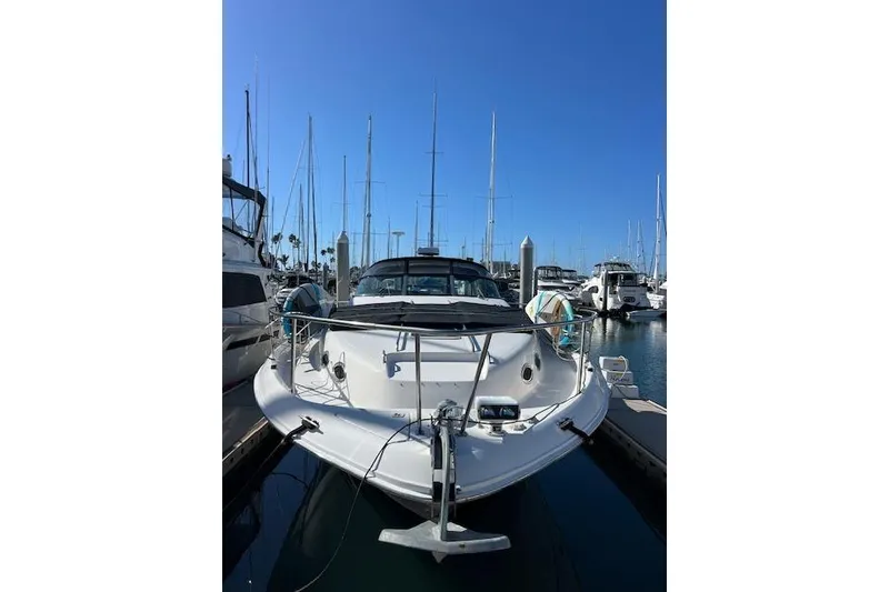 Slide: The Image of 1997 Sea Ray 450 Sundancer yacht docked at marina under clear blue sky. - 2