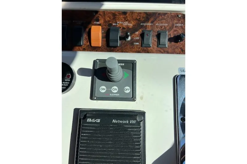 Slide: The Image of Control panel of a 1997 Sea Ray 450 Sundancer boat with switches and joystick. - 23