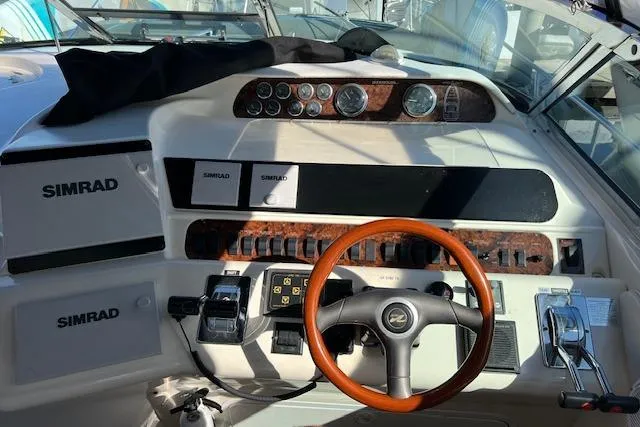 Slide: The Image of Cockpit of 1997 Sea Ray 450 Sundancer with Simrad navigation and wooden steering wheel. - 24