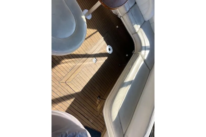 Slide: The Image of 1997 Sea Ray 450 Sundancer interior with wooden flooring and cushioned seating. - 26
