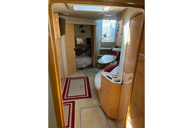 Slide: The Image of Interior of 1997 Sea Ray 450 Sundancer yacht, featuring cozy seating and elegant wood finishes. - 31