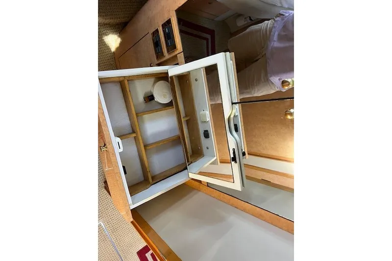 Slide: The Image of 1997 Sea Ray 450 Sundancer interior cabinet with open door, showcasing storage space. - 32