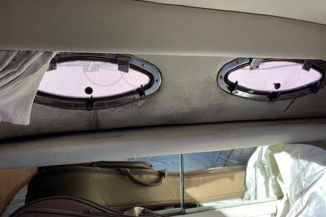 Slide: The Image of Interior view of 1997 Sea Ray 450 Sundancer with oval windows and luggage. - 34