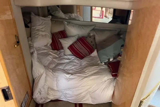 Slide: The Image of Cozy cabin interior of 1997 Sea Ray 450 Sundancer with plush bedding and pillows. - 36