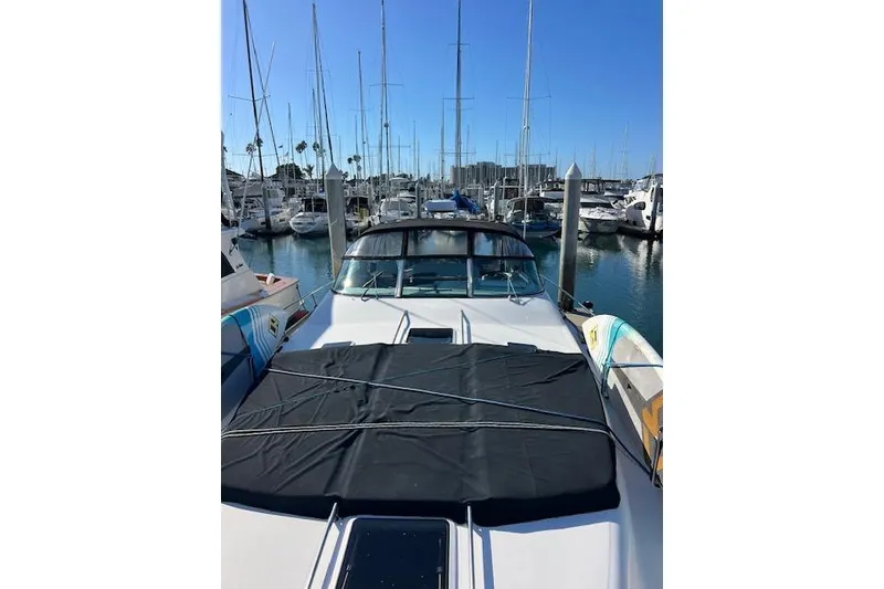Slide: The Image of 1997 Sea Ray 450 Sundancer yacht docked in a marina with sailboats. - 46