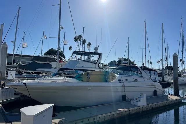 Slide: The Image of 1997 Sea Ray 450 Sundancer yacht docked at a marina under clear blue skies. - 56