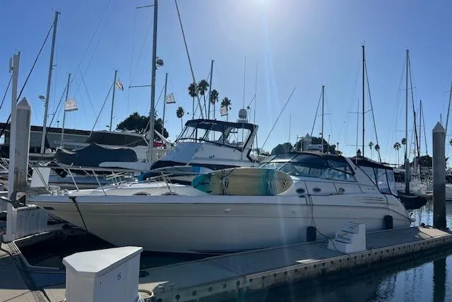 Slide: The Image of 1997 Sea Ray 450 Sundancer yacht docked at marina under clear blue sky. - 57