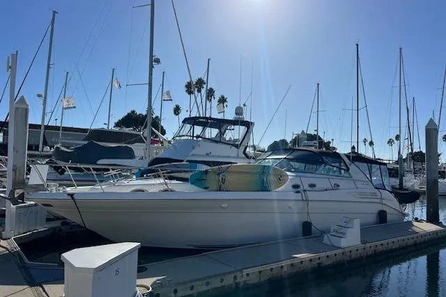 Slide: The Image of 1997 Sea Ray 450 Sundancer yacht docked at marina under clear blue sky. - 58