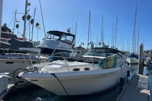 Slide: The Image of 1997 Sea Ray 450 Sundancer yacht docked at marina with clear blue sky. - 6