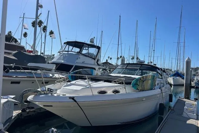 Slide: The Image of 1997 Sea Ray 450 Sundancer yacht docked in a marina with other boats. - 7