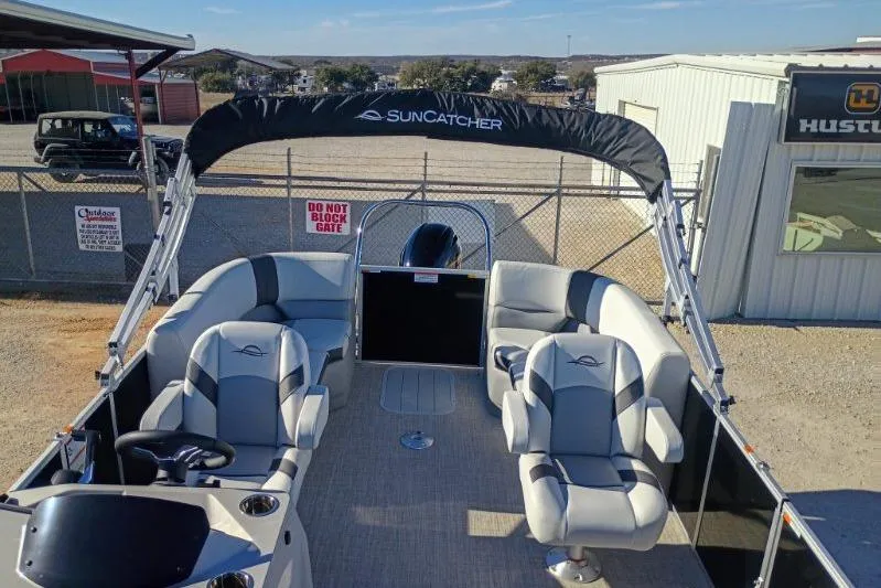 The Image of 2026 SunCatcher Select 20RC pontoon boat with spacious seating and canopy in a dealership lot. - 0