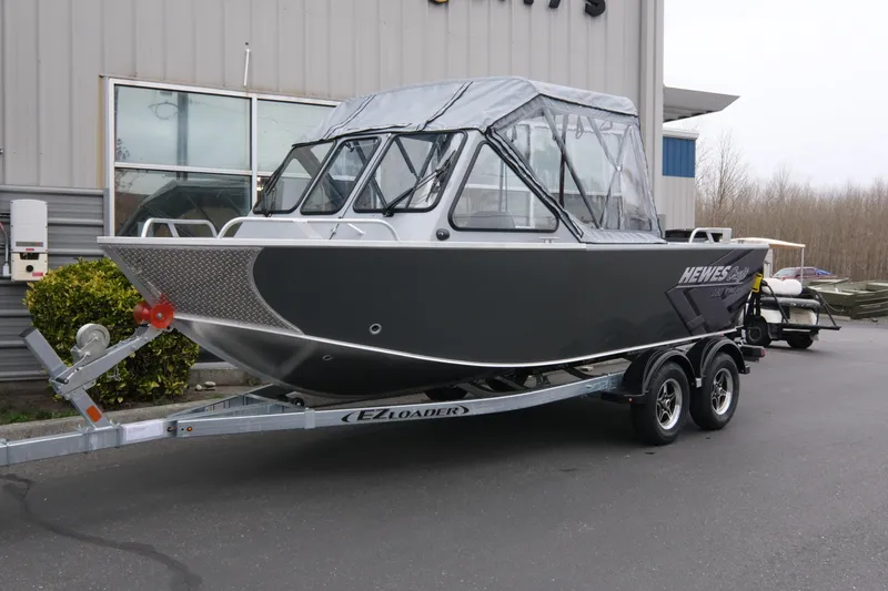 The Image of 2026 Hewescraft 180 ProV ET boat on trailer, parked outside a building. - 0