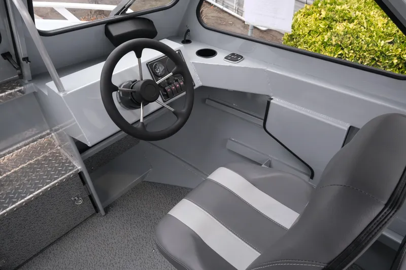 Slide: The Image of Interior of 2026 Hewescraft 180 ProV ET boat, featuring steering wheel and seating. - 10