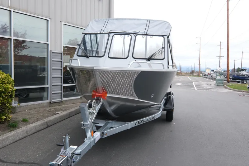 Slide: The Image of 2026 Hewescraft 180 ProV ET boat on trailer outside a building. - 2