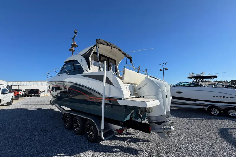 Slide: The Image of 2020 Beneteau Antares 27 boat on trailer, parked outdoors under clear blue sky. - 12