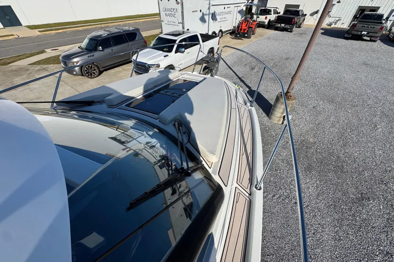 Slide: The Image of 2020 Beneteau Antares 27 boat docked, with cars and trailers in the background. - 18