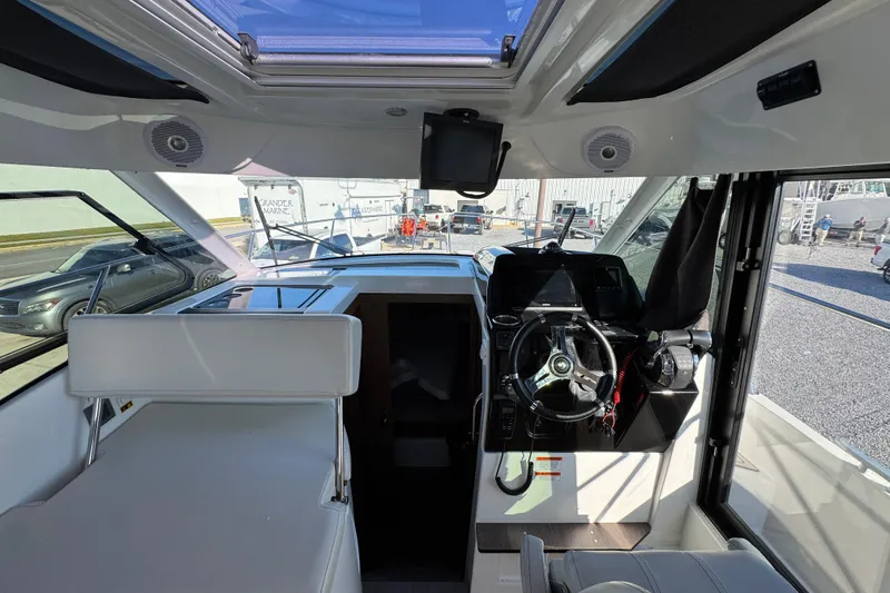 Slide: The Image of Interior view of 2020 Beneteau Antares 27 boat cockpit with steering wheel and seating. - 25