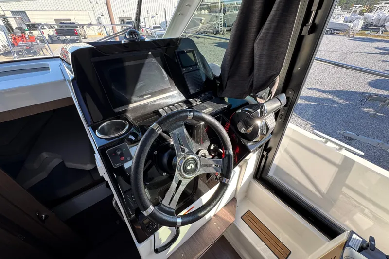 Slide: The Image of Helm station of 2020 Beneteau Antares 27 with steering wheel and navigation controls. - 26
