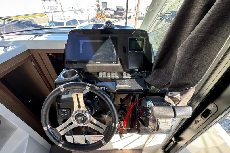 Slide: The Image of 2020 Beneteau Antares 27 helm with steering wheel and navigation controls. - 27