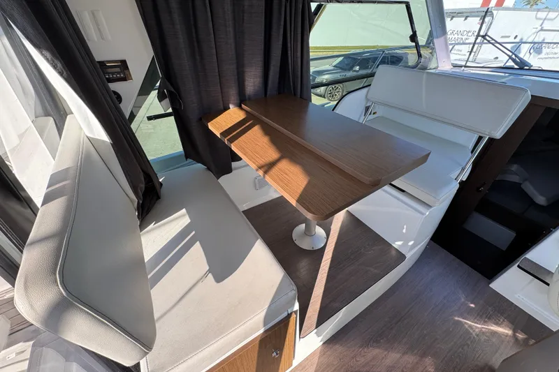 Slide: The Image of Interior of 2020 Beneteau Antares 27 with seating and wooden table. - 36