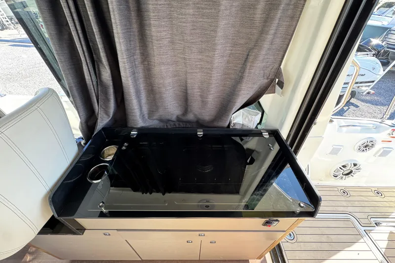 Slide: The Image of Interior of 2020 Beneteau Antares 27 with sleek black countertop and cup holders. - 38