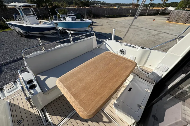 Slide: The Image of 2020 Beneteau Antares 27 boat deck with seating and wooden table. - 44