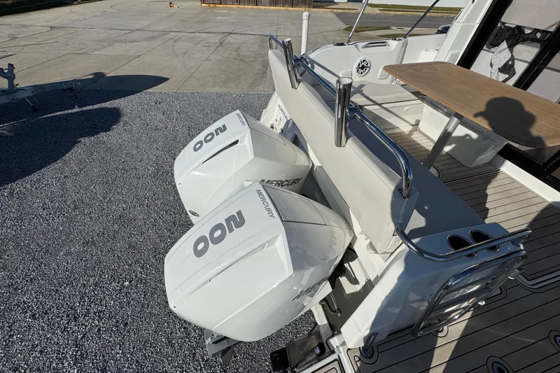 Slide: The Image of 2020 Beneteau Antares 27 with dual Mercury outboard engines, docked on gravel. - 45