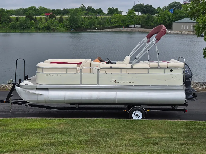 The Image of 2007 Bennington 2075GL pontoon boat on trailer by a lake. - 0
