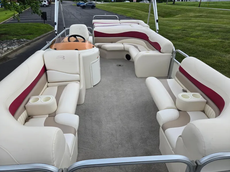 Slide: The Image of 2007 Bennington 2075GL pontoon boat with spacious seating and cup holders, parked on grass. - 10
