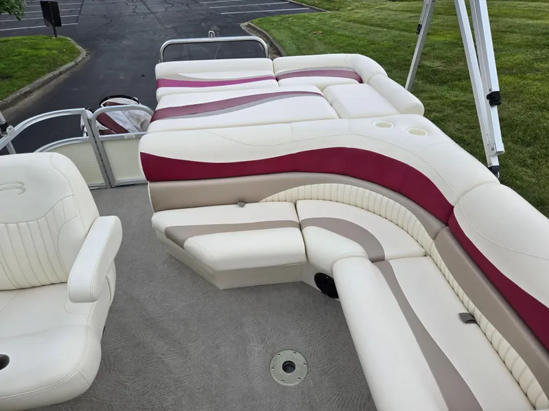 Slide: The Image of 2007 Bennington 2075GL boat interior with white and maroon seating, parked on pavement. - 13