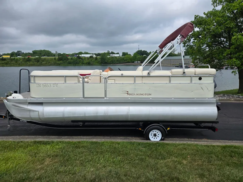 Slide: The Image of 2007 Bennington 2075GL pontoon boat on trailer by a lake. - 9