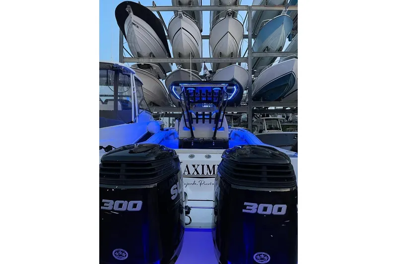 Slide: The Image of 2020 Tidewater 320 CC Adventure boat with dual 300 horsepower engines, docked with blue lighting. - 12