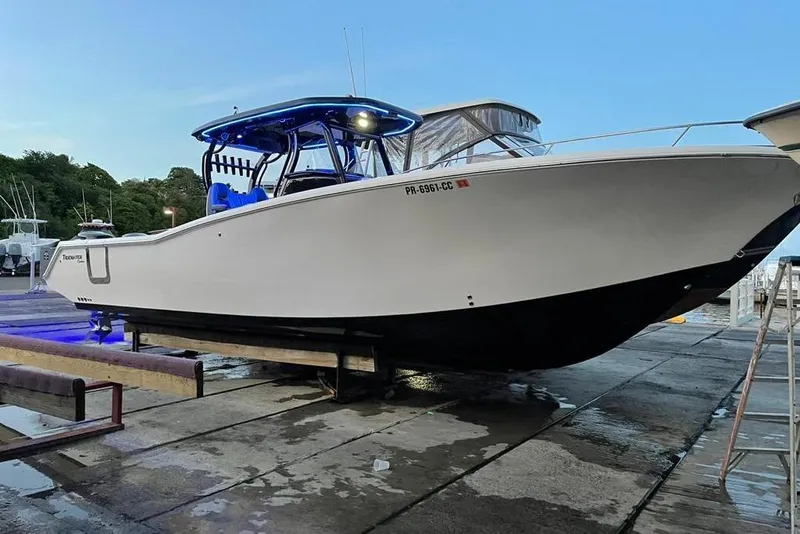 Slide: The Image of 2020 Tidewater 320 CC Adventure boat on a dock, side view. - 14