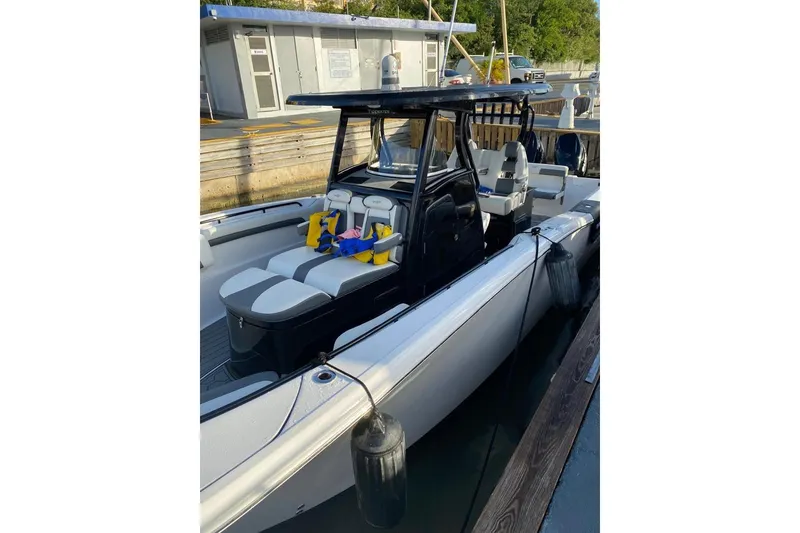 Slide: The Image of 2020 Tidewater 320 CC Adventure boat docked, featuring sleek design and comfortable seating. - 6