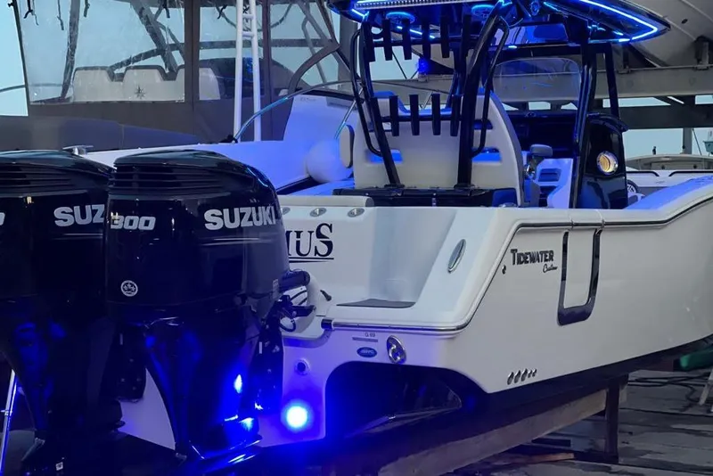 Slide: The Image of 2020 Tidewater 320 CC Adventure boat with dual Suzuki engines and blue LED lighting. - 9