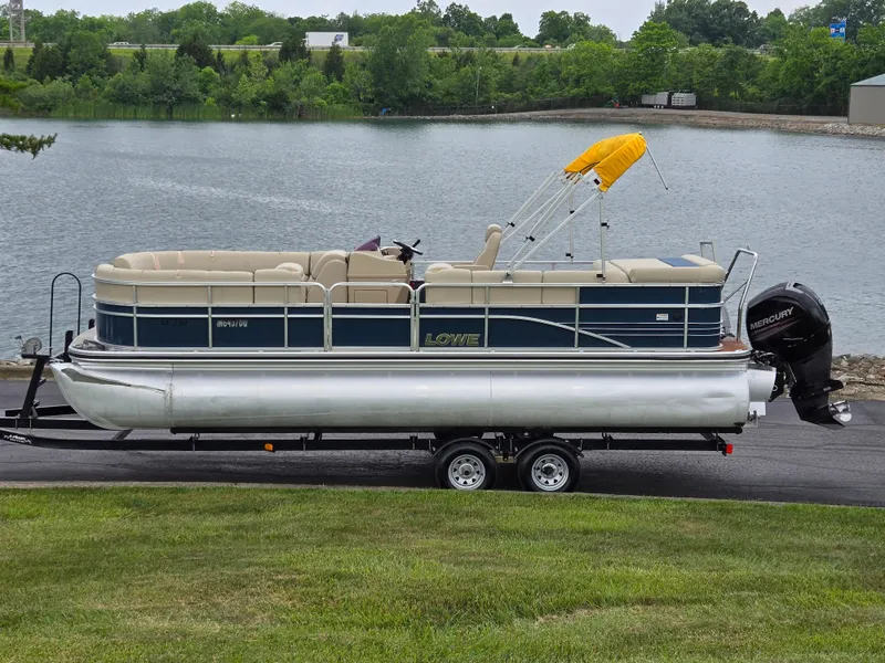 The Image of 2014 Lowe SS230 Super Sport pontoon boat on trailer by a lake. - 0