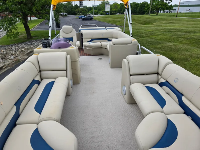 Slide: The Image of 2014 Lowe SS230 Super Sport pontoon boat with beige and blue seating, parked on grass. - 12