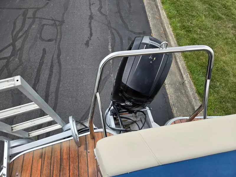 Slide: The Image of 2014 Lowe SS230 Super Sport boat with outboard motor and ladder on a paved surface. - 18