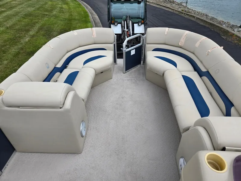 Slide: The Image of 2014 Lowe SS230 Super Sport pontoon boat with beige and blue seating, parked near water. - 23