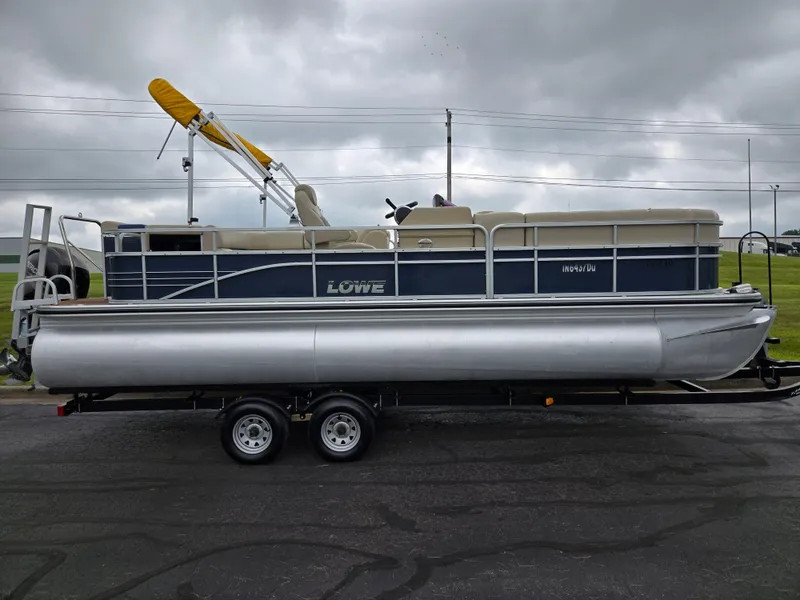 Slide: The Image of 2014 Lowe SS230 Super Sport pontoon boat on trailer, overcast sky background. - 4