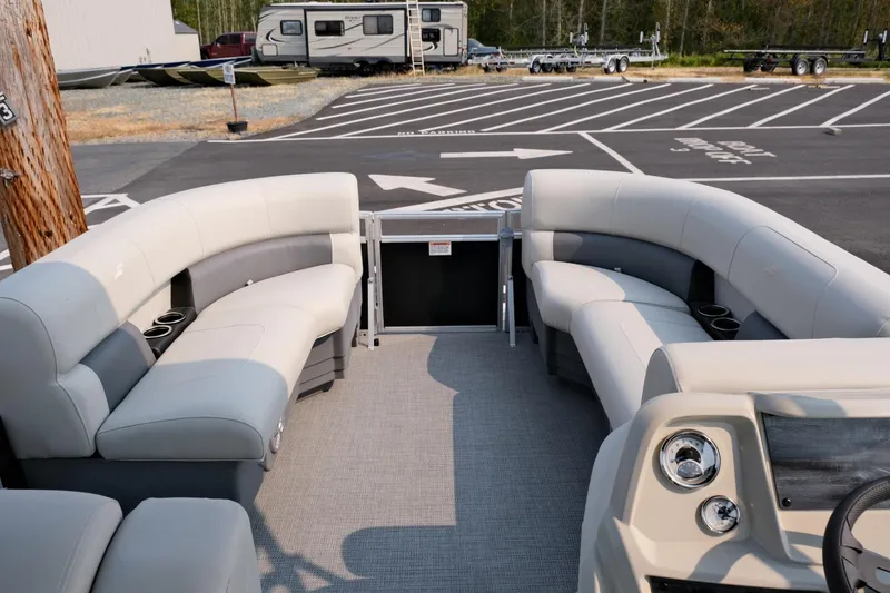 Slide: The Image of 2023 Starcraft LX 18 R pontoon boat interior with plush seating and modern dashboard. - 16