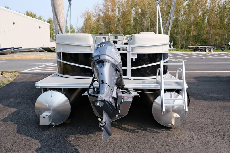 Slide: The Image of 2023 Starcraft LX 18 R pontoon boat with outboard motor, parked on asphalt. - 4