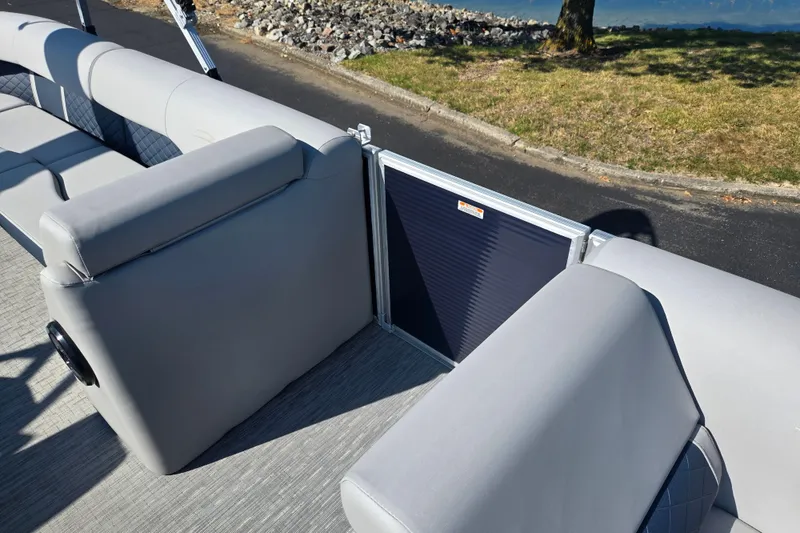 Slide: The Image of 2022 Bennington L 22 Quad Bench boat interior with gray seating and lake view. - 13
