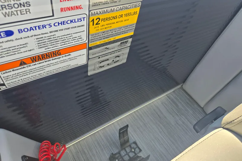 Slide: The Image of 2022 Bennington L 22 Quad Bench capacity and safety labels on boat interior. - 15