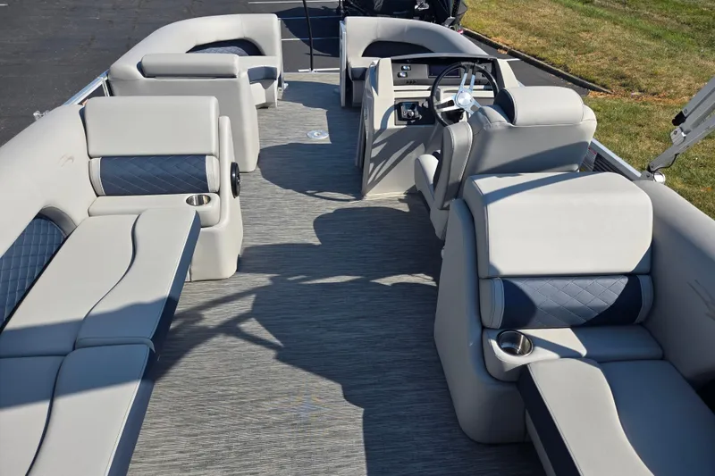 Slide: The Image of 2022 Bennington L 22 Quad Bench pontoon boat interior with luxurious seating and steering console. - 19