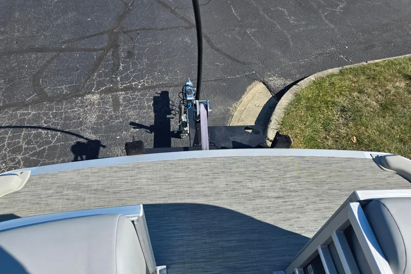 Slide: The Image of 2022 Bennington L 22 Quad Bench pontoon boat on trailer, parked on asphalt. - 23