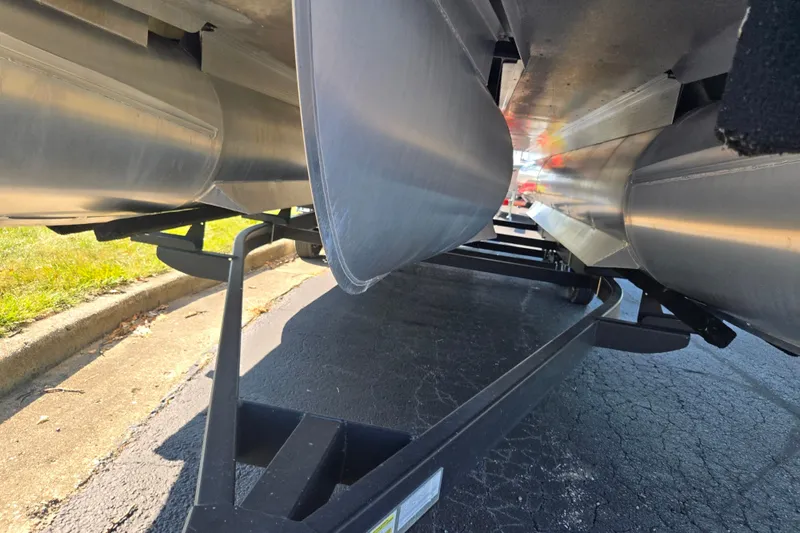 Slide: The Image of Underneath view of a 2022 Bennington L 22 Quad Bench pontoon on a trailer. - 7
