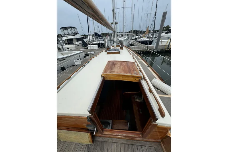 Slide: The Image of 1960 Alden Challenger 38 sailboat deck view in marina, showcasing wooden details and open cabin. - 10